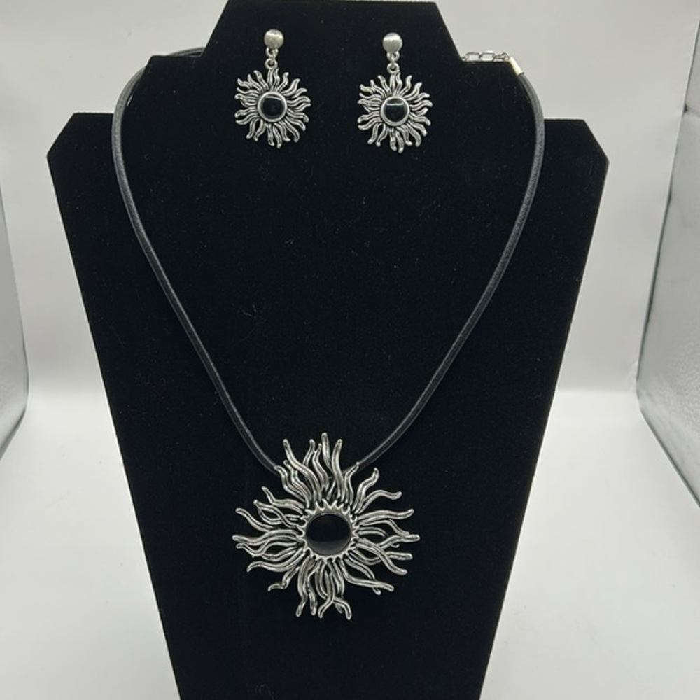 Silvertone sunburst necklace and earring set.  Leather strap.